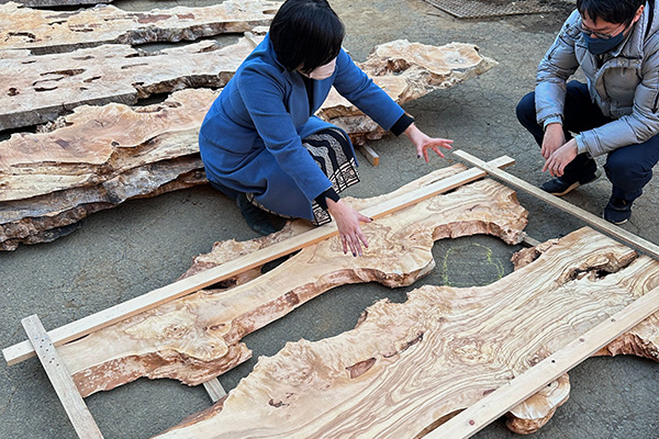 レジンテーブルの選び方のトップ画像でお客様が倉庫で両手を広げてデザインする様子